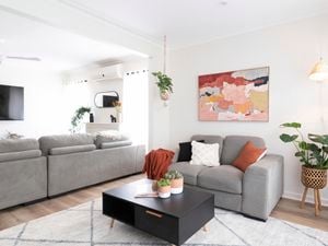 Living room with couch, coffee table and rug.